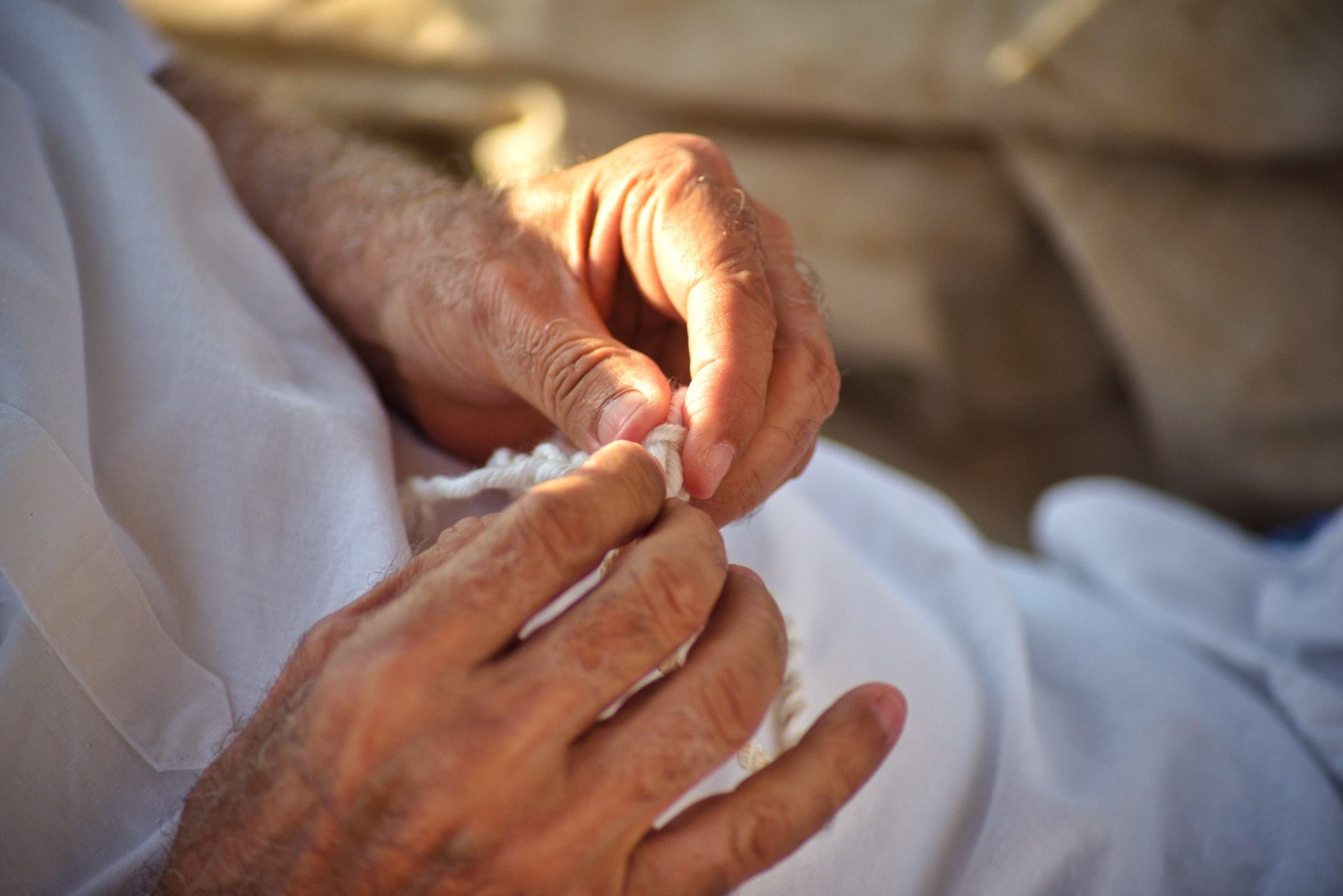 Old man hands stringing bracelet